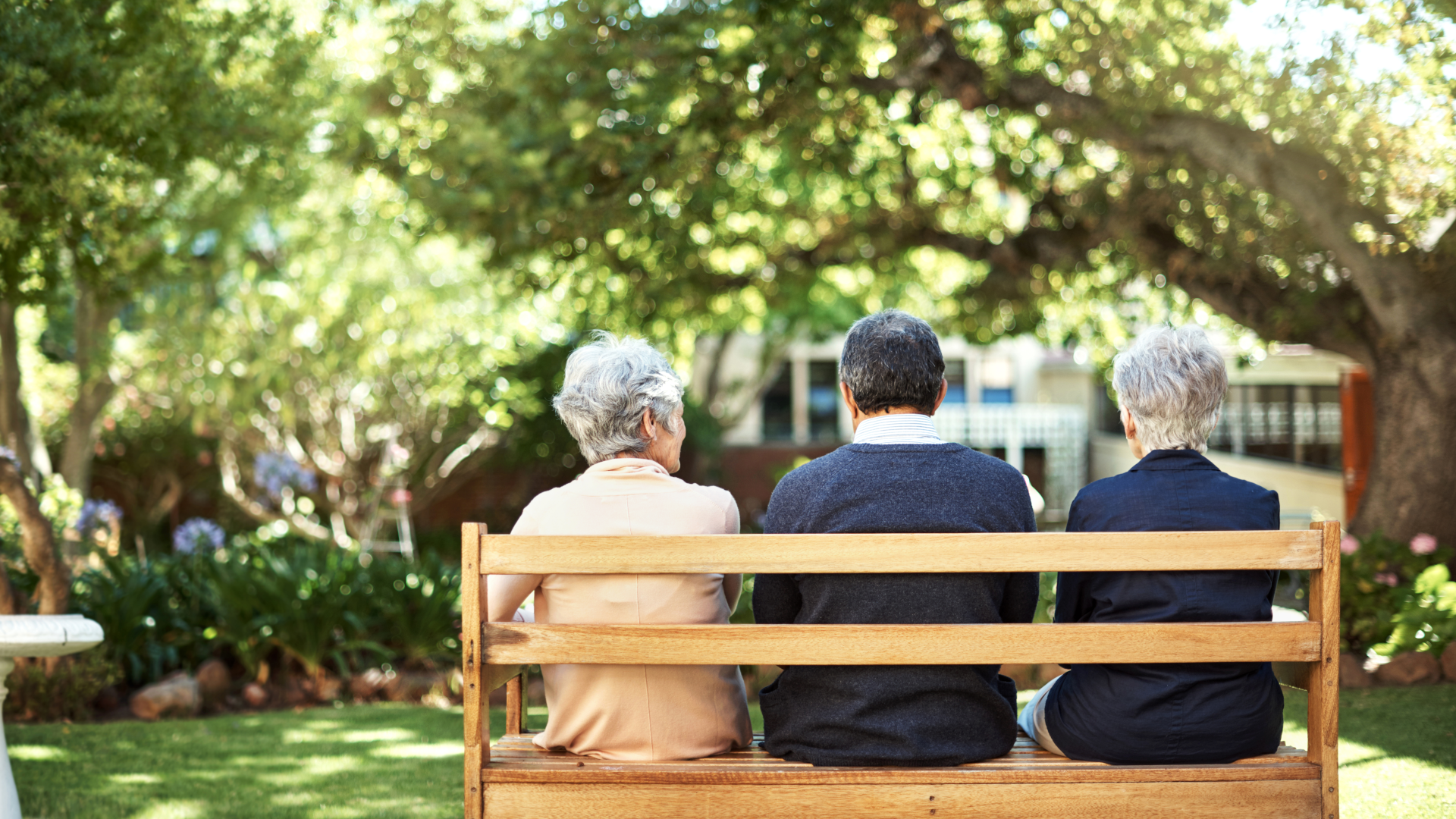 three pensioners on a park bench in a garden