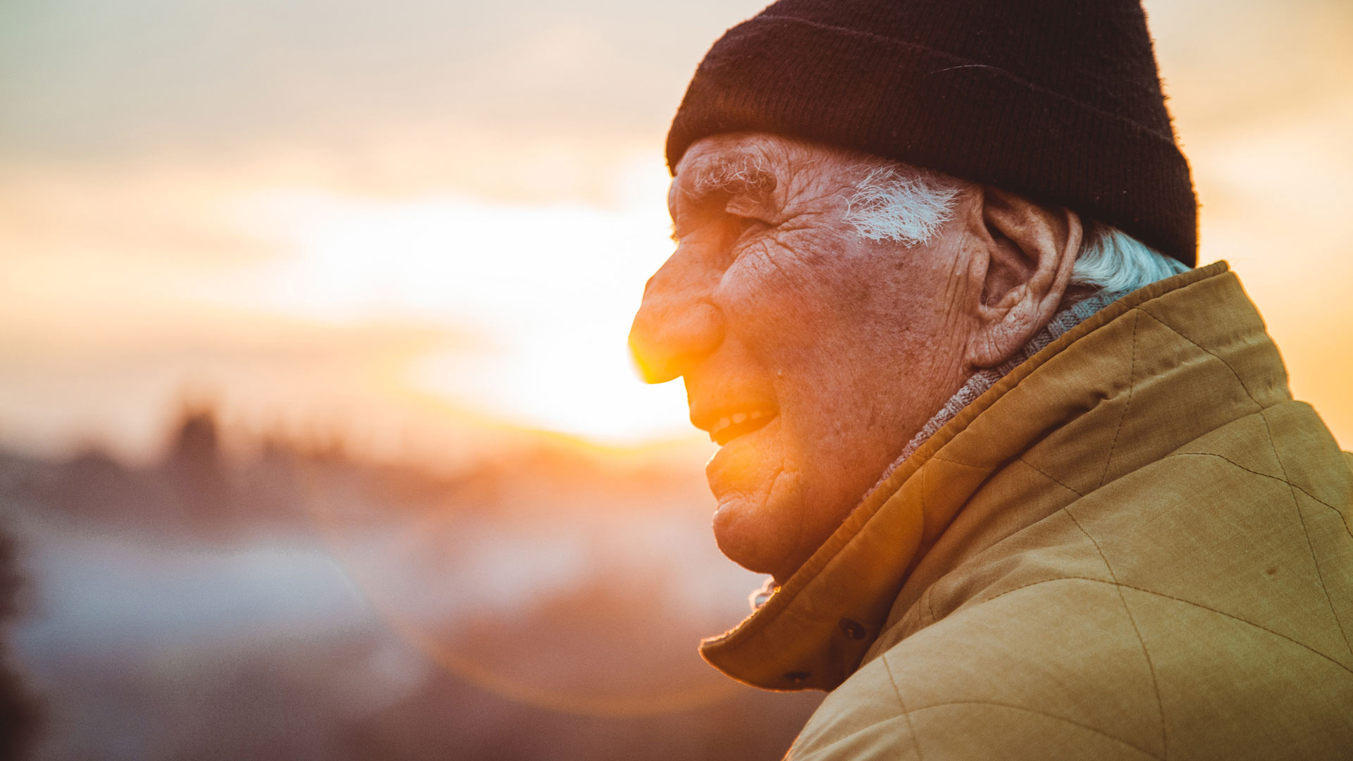 retiree smiling in front of sunset 