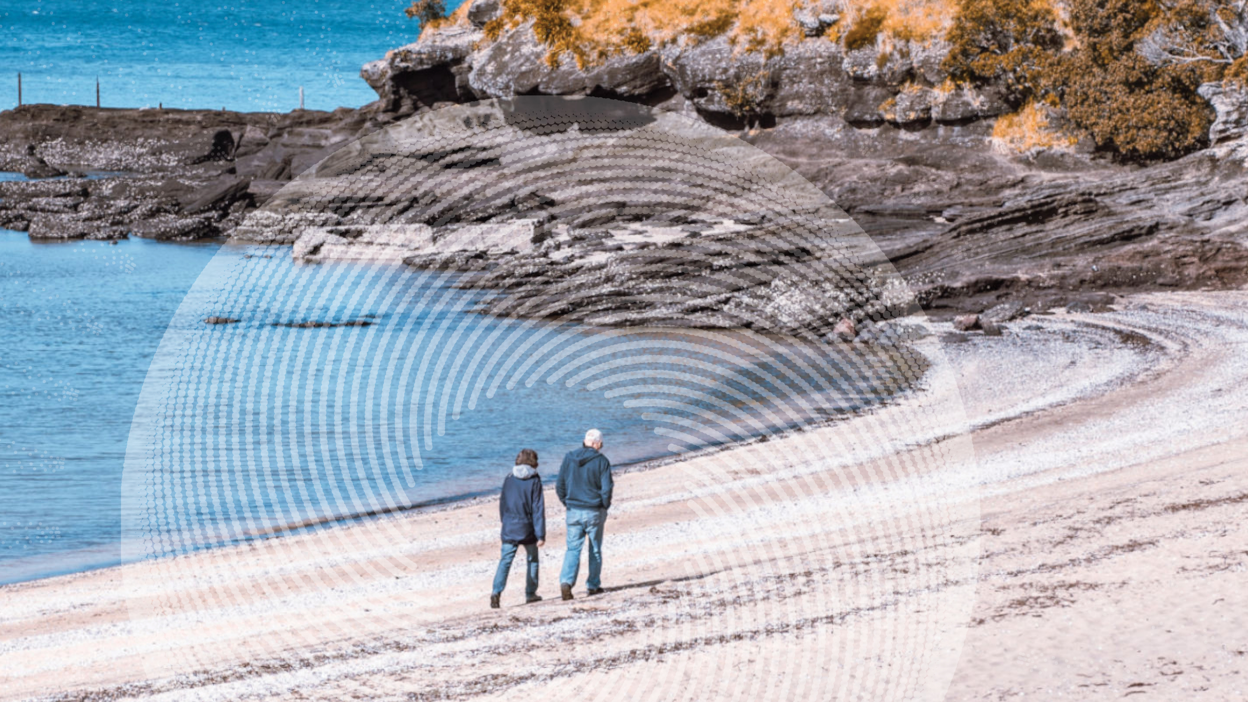 two old people walking on a beach