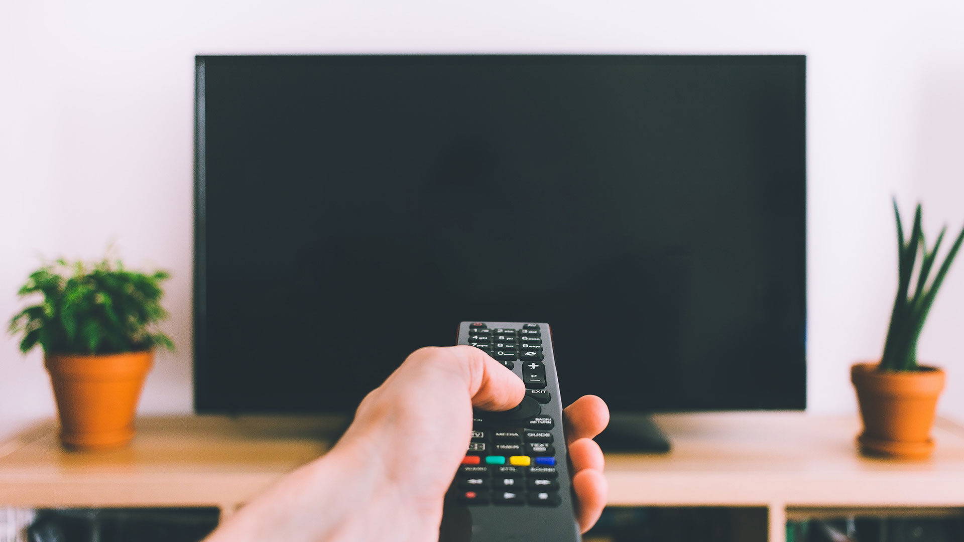man holding tv remote control 